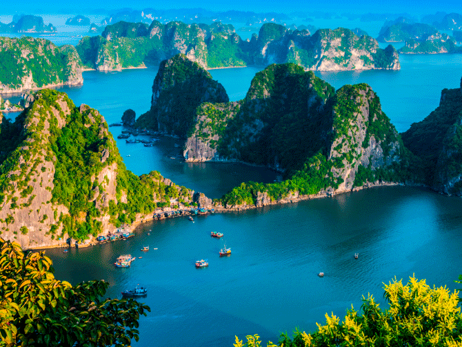 Vista panorámica de la Bahía de Ha Long en Vietnam con islotes de piedra calcárea y barcos tradicionales Vista panorámica de la Bahía de Ha Long en Vietnam con islotes de piedra calcárea y barcos tradicionales
