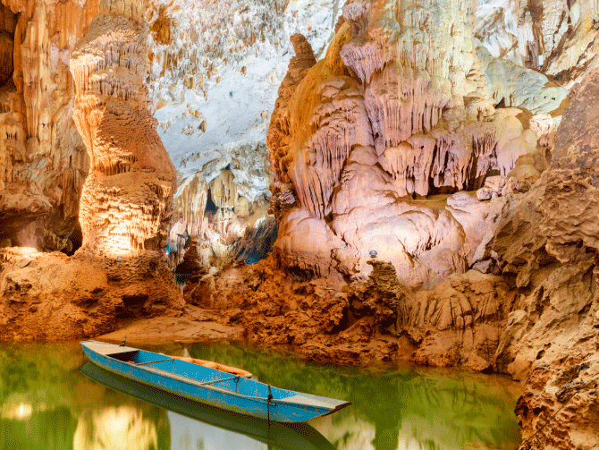 Barca azul flotando en el río subterráneo de una cueva de Phong Nha en Vietnam Barca azul flotando en el río subterráneo de una cueva de Phong Nha en Vietnam